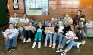 girls basketball team with items to be donated to Covenant Kids